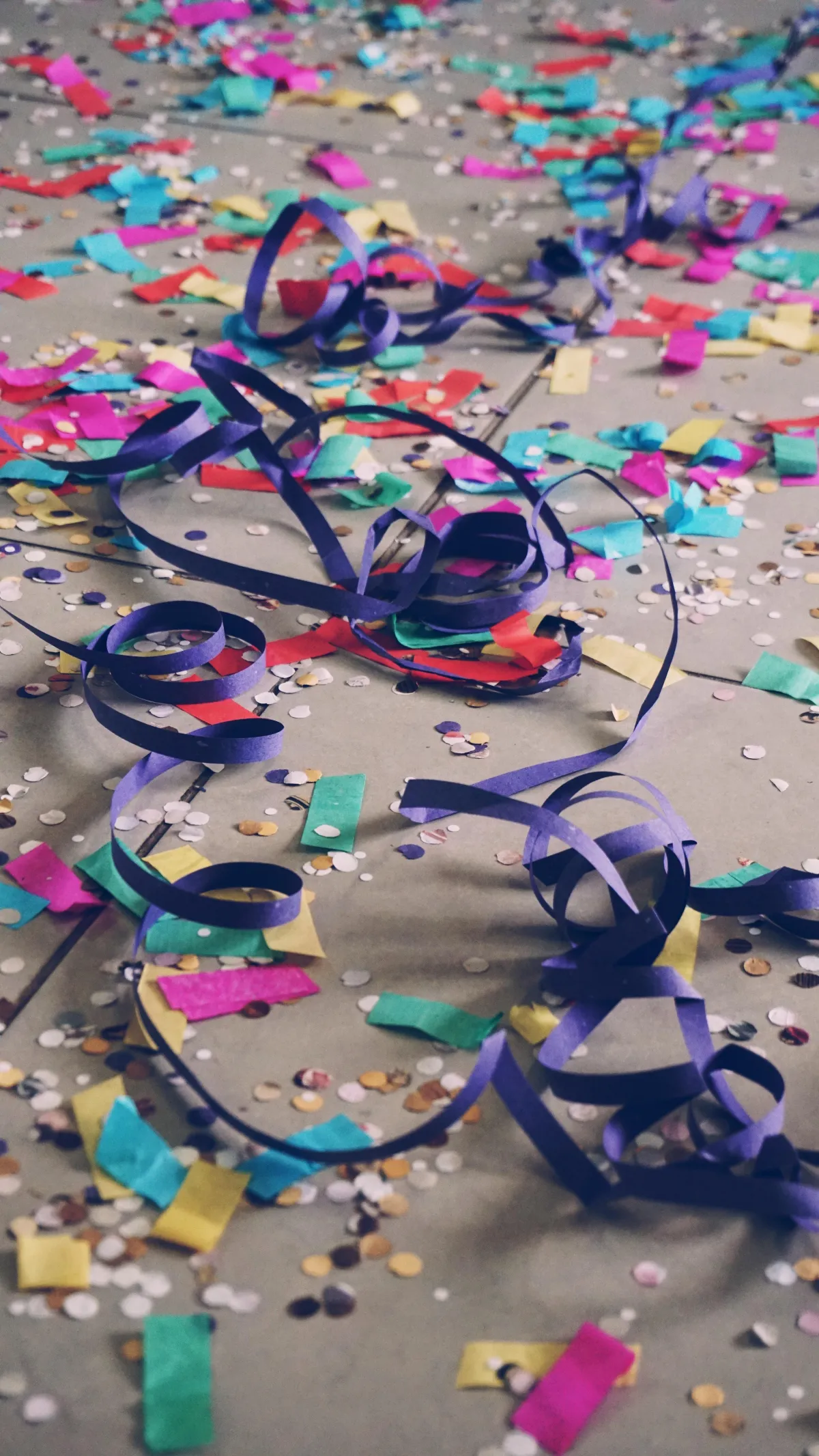 Multicolored confetti and streamers lay on the ground after a new year's eve celebration