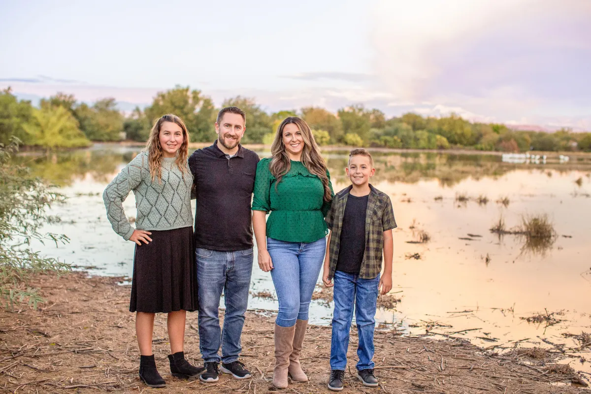 Family of four standing by the lake at Nichols Park in Gilbert AZ during sunset family photos.