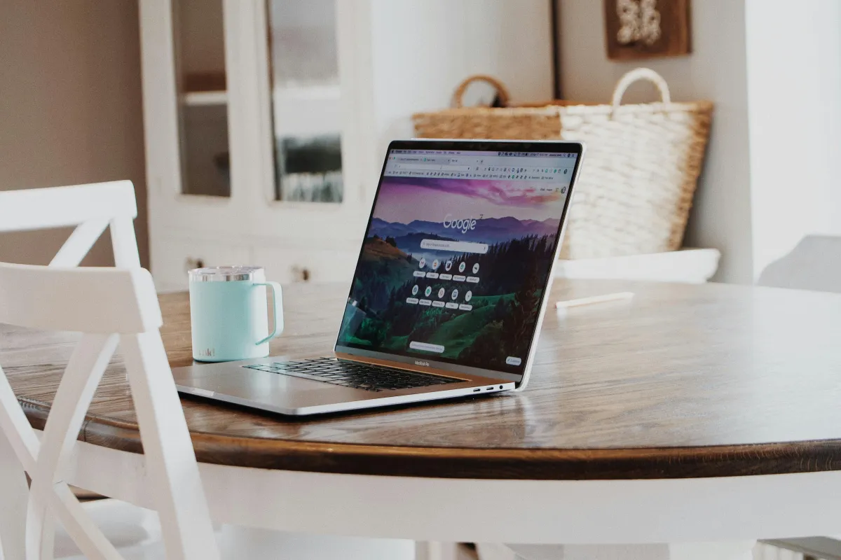 Laptop, desk, and mug on a table.