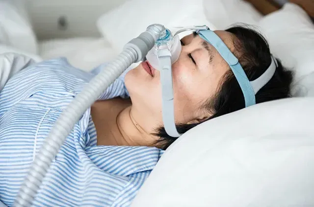 Woman wearing a CPAP sleep apnea mask.
