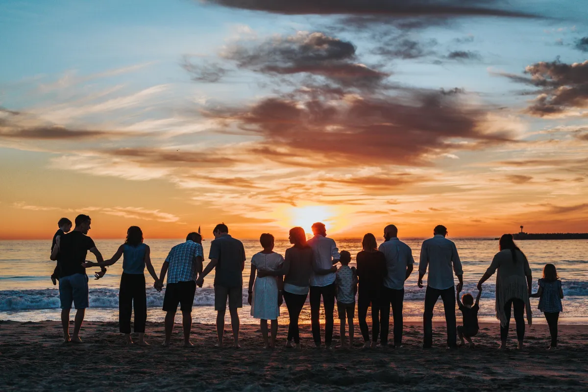 Family standing on the shore at sunset - Life Insurance