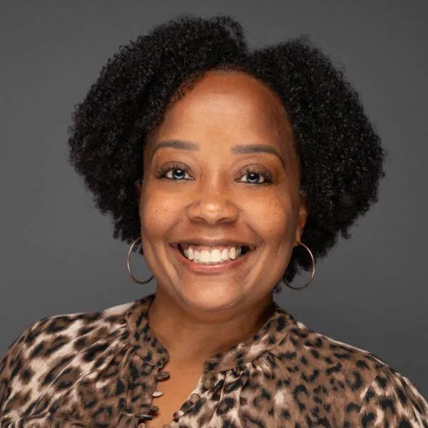 Professional headshot of a smiling Black female officer in business attire for social profile.