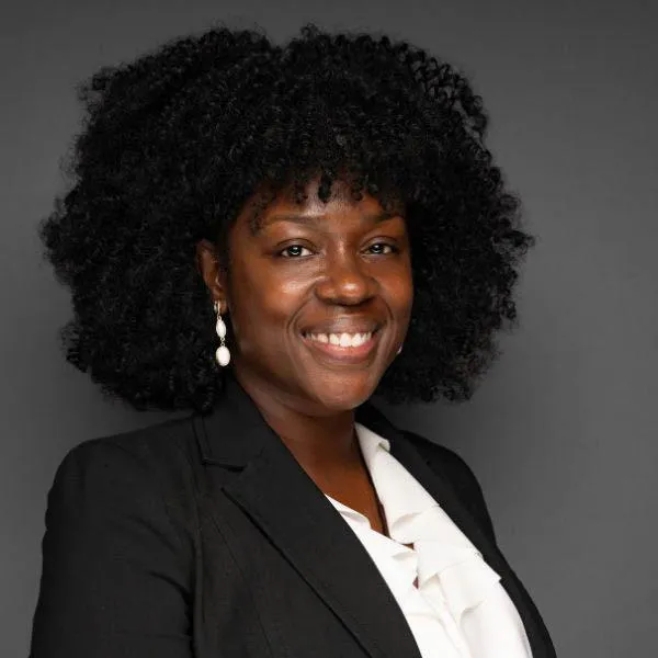 Professional headshot of a smiling Black female officer in business attire for social profile