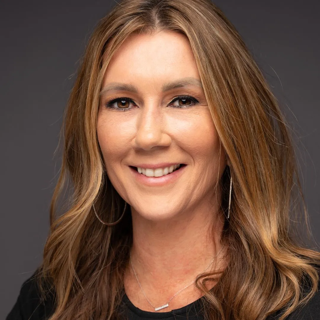 Professional headshot of a smiling female officer in business attire, taken for personal branding and social profiles