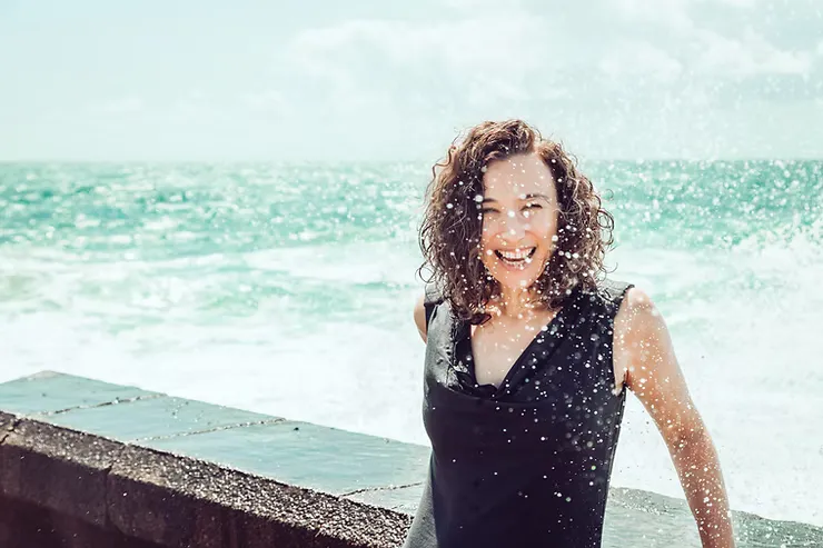 female smiling behind the breakwater