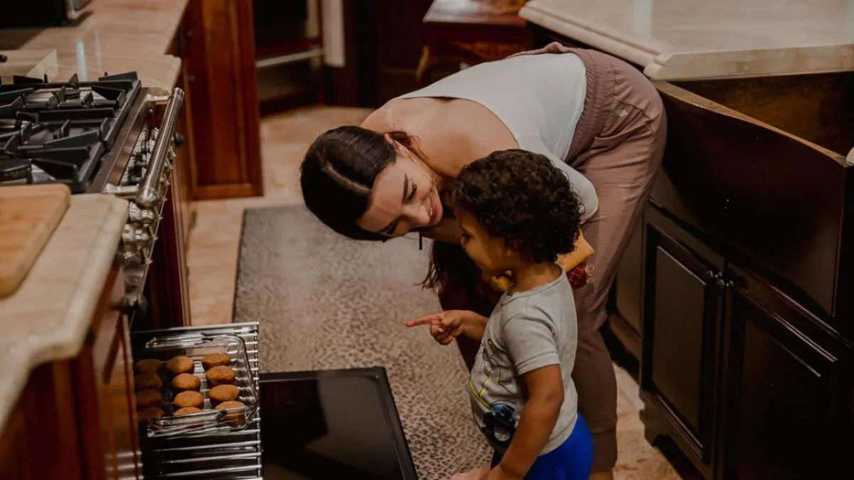 CeCe with her child looking at glass cookware in an oven
