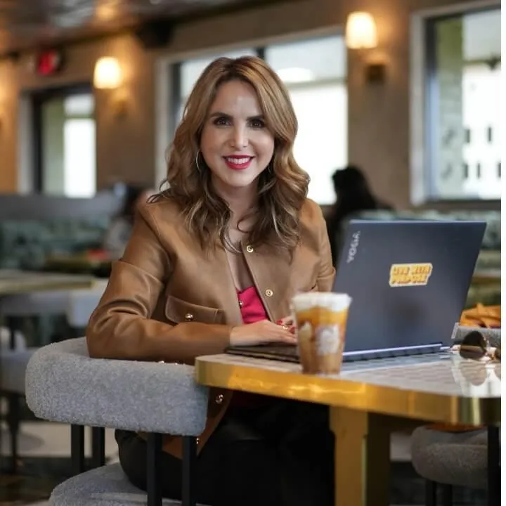 Claudia Cantu Flores at a coffee shop on laptop 