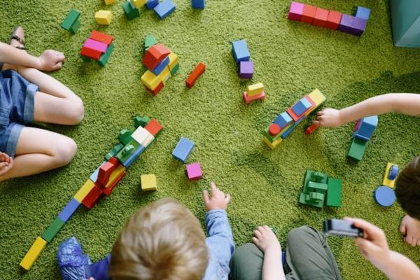 children playing in a colorful preschool classroom - what makes a high quality preschool program