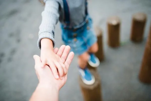 a child's hand holding an adult's hand - balanced parenting