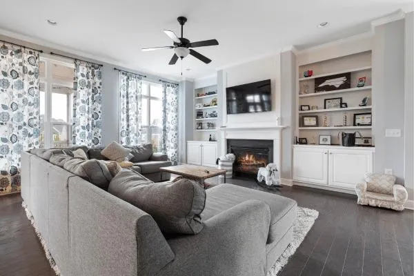 Cozy and stylishly appointed living room showcasing good interior design that promotes well-being, with comfortable seating, a warm fireplace, and built-in shelves.