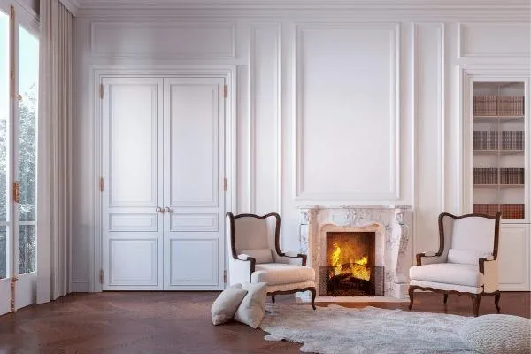 Victorian-inspired living room with a modern twist reflecting European style influence in Edmonton's interior design, featuring a classic fireplace and elegant furnishings.