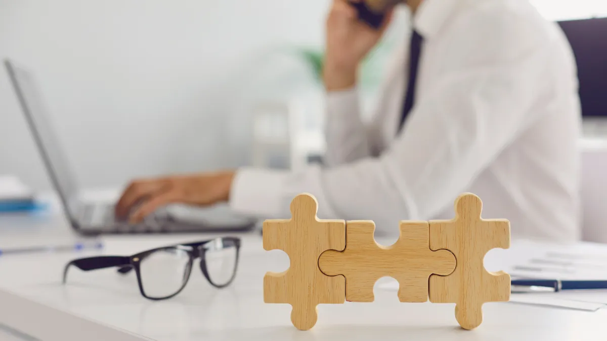 individual sitting at a computer with puzzle pieces in the image