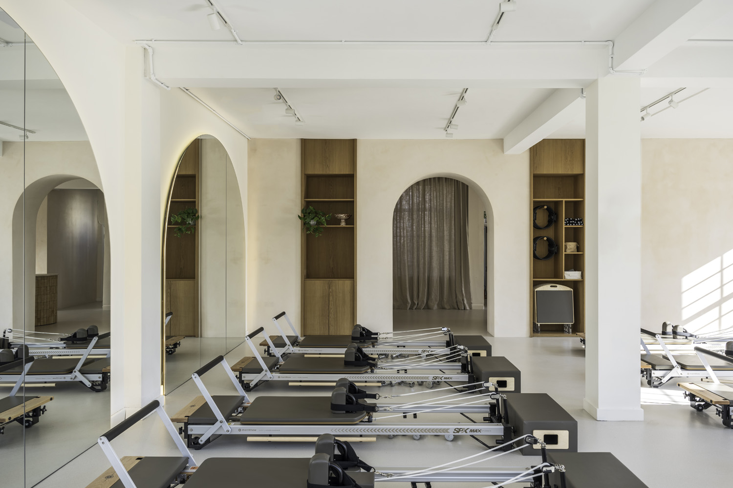 performing a Pilates reformer exercise in a bright studio, conveying strength, focus, and calm determination.