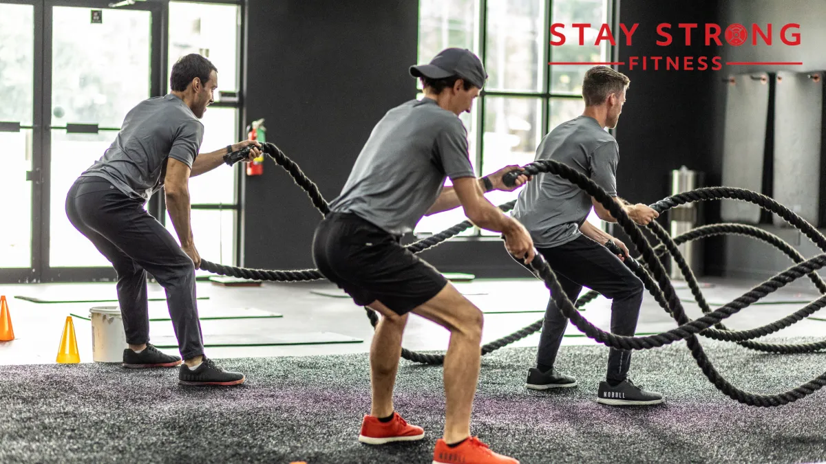 A couple of people exercising at the gym, focused and determined.