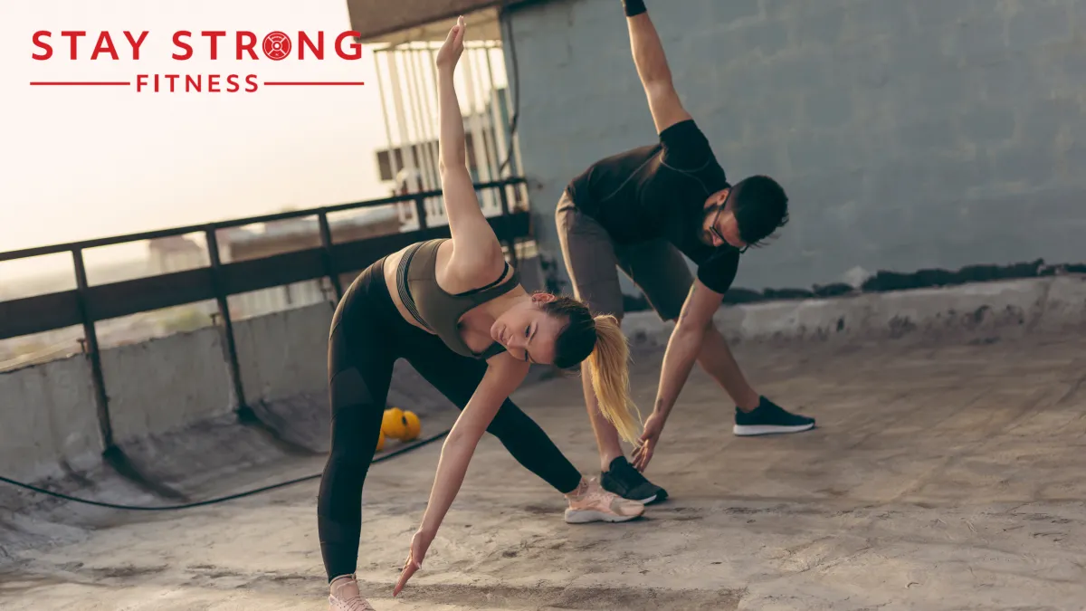 Two individuals stretching their bodies on the rooftop.