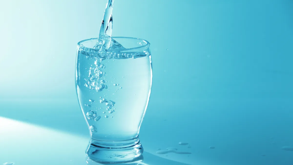 A glass being filled with water, creating a refreshing and hydrating beverage.