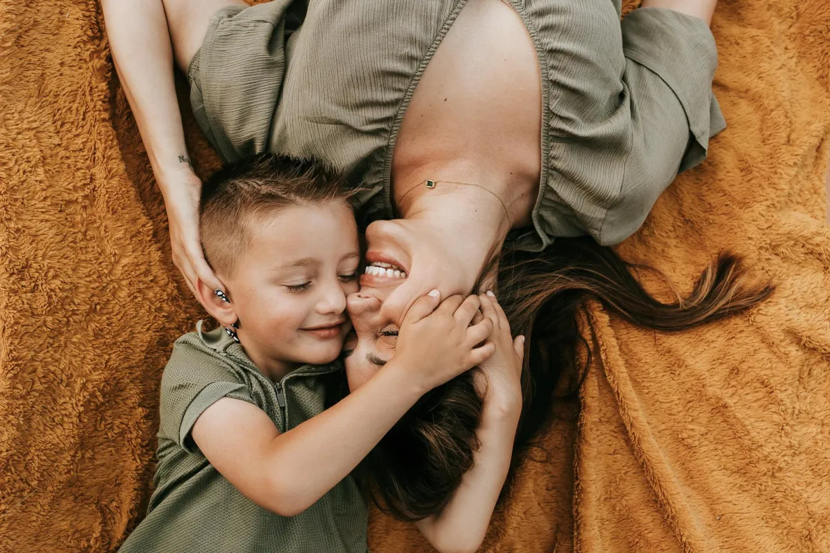 Photography of mother and son snuggling on a blanket
