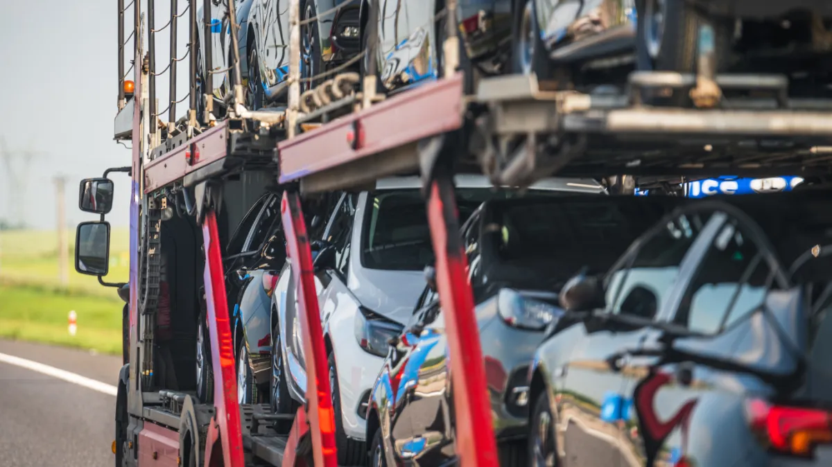 Family's fleet of vehicles loaded onto an open transporter for a hassle-free relocation.