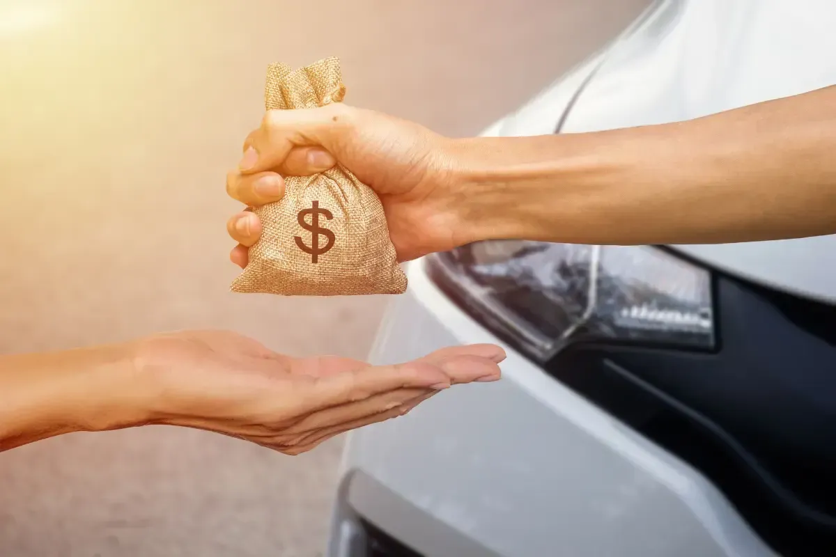 Mano entregando una bolsa de dinero, representando cómo lograr tu primera venta