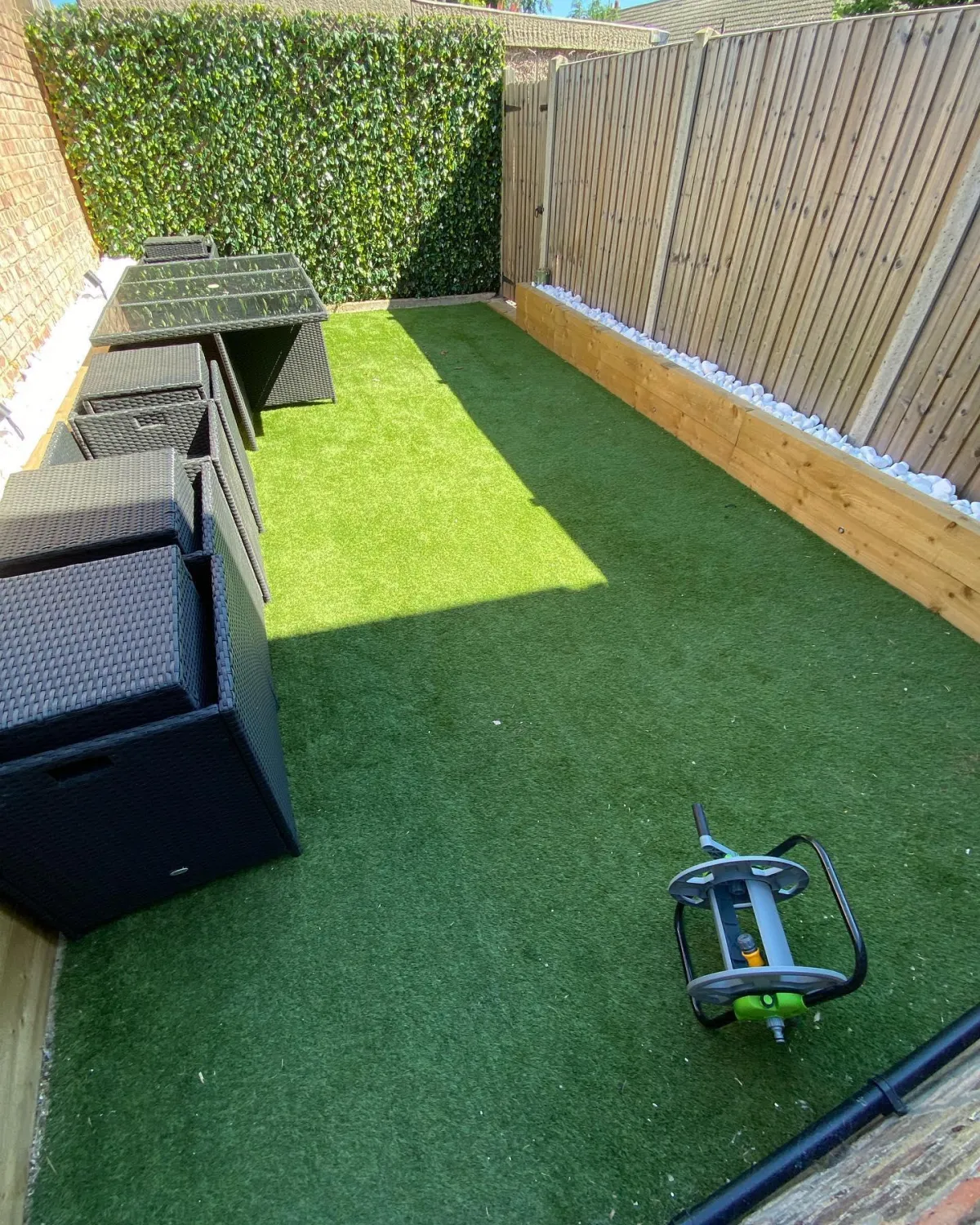 Small side garden with artificial grass and outdoor dining furniture