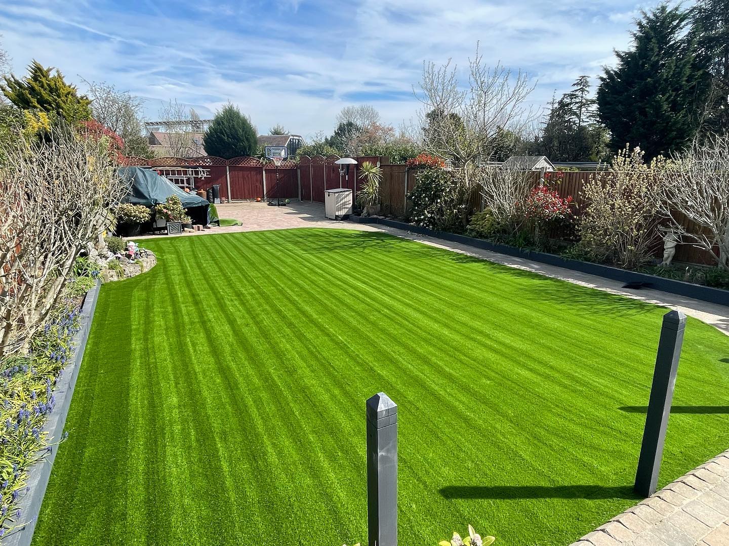 Large landscaped garden with a striped artificial grass lawn