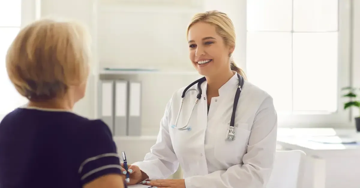 Smiling healthcare provider consulting with a patient, reflecting the personalized care and root-cause approach emphasized in functional wellness programs.