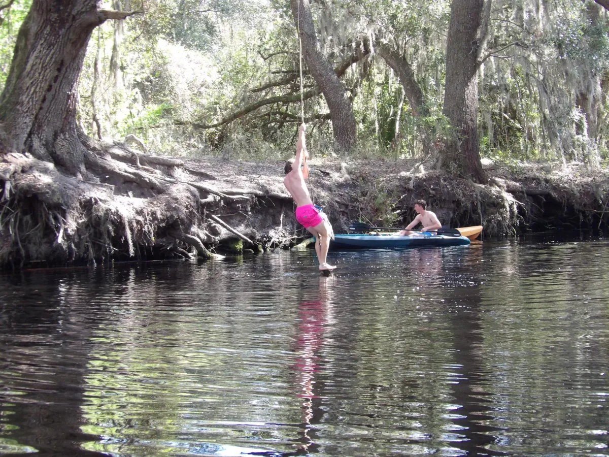 Person swinging to the water