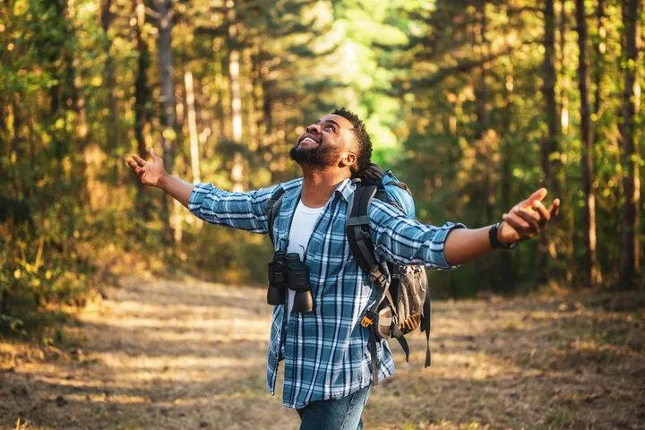 Happy man on forest trail, symbolizing a journey towards healing and understanding autism.