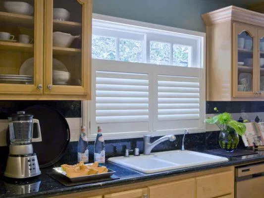 White Café Style Shutters covering the lower half of a kitchen window in a Houston home.