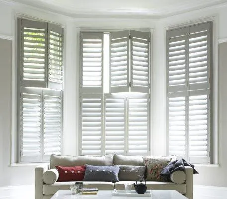 Tier-on-tier plantation shutters in a Houston living room with top open and bottom closed for privacy