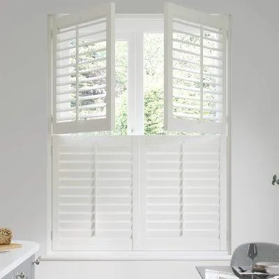 Bedroom with tier-on-tier shutters providing nighttime privacy and daytime light