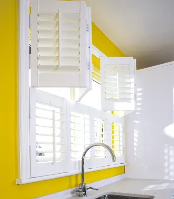 Modern white tier-on-tier shutters complementing a bright Houston interior