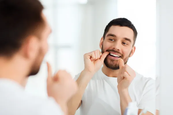 Man flossing teeth to support gum and brain health