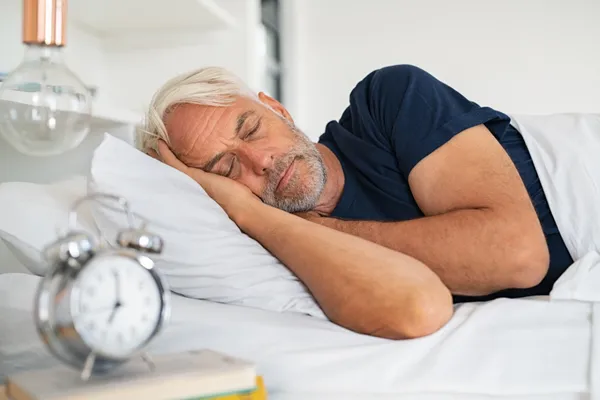Man sleeping well following sleep-boosting strategies for better metabolism and mental clarity.