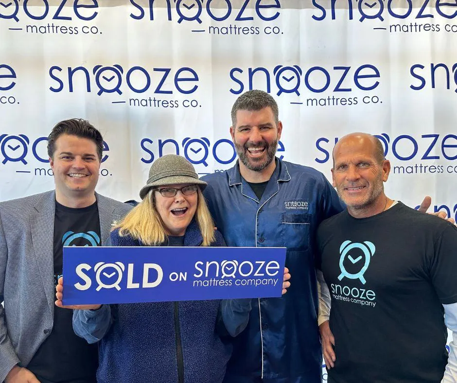 Nico Marasco, John Wanninger owners of Snooze Mattress Co. in Omaha, NE, pose with Matt Smith, CEO and Founder of Snooze Mattress Co., pose with the winner of a Tempur-Pedic bedset valued at $15,000 at the Grand Opening celebration.