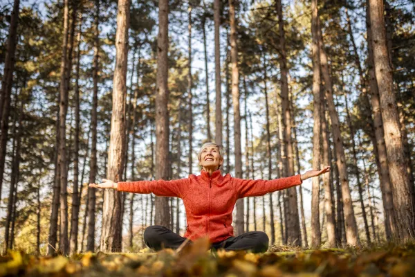Image of a senior practicing self-compassion, such as through meditation, journaling, or spending time in nature.