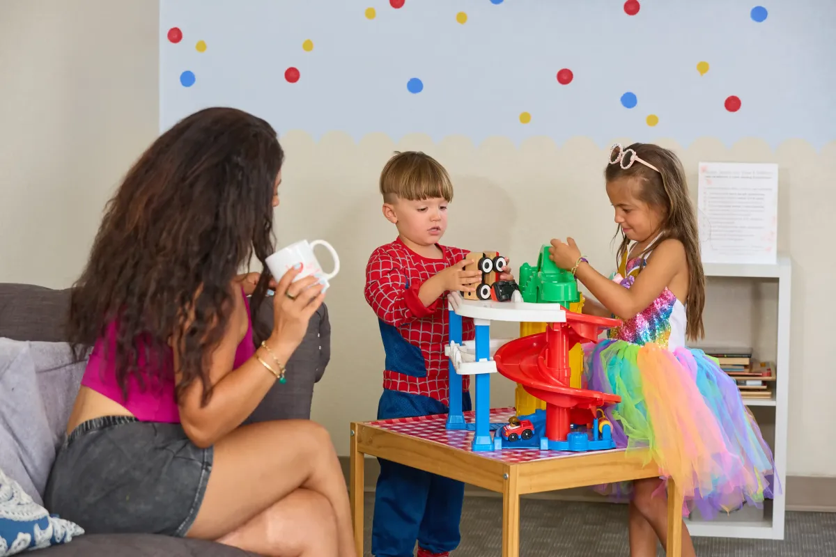 A mom and her children enjoy the children's waiting area at Cardinal Dental of St. Peters