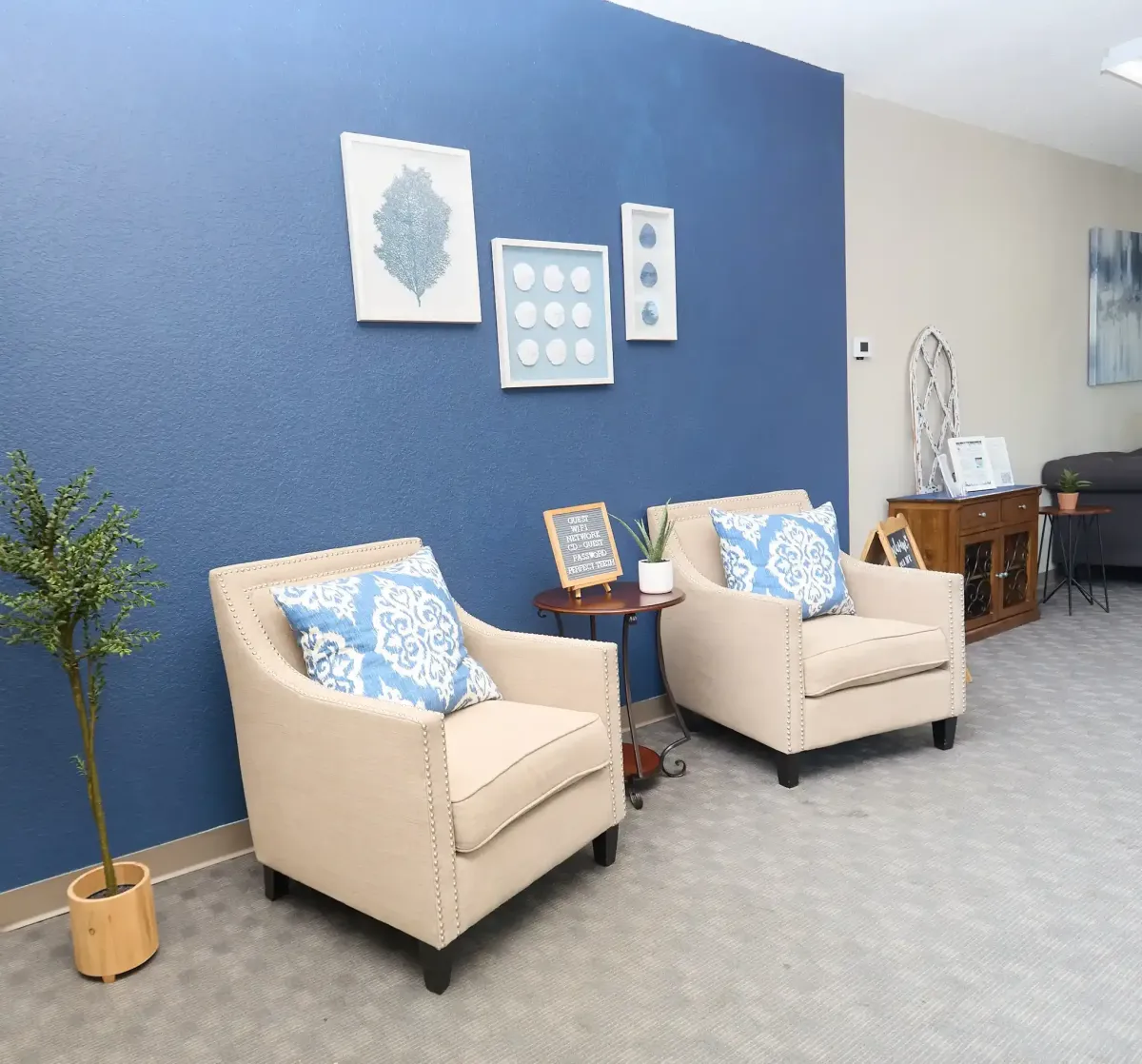 Stylish armchair seating against a bold blue accent wall in the patient lobby