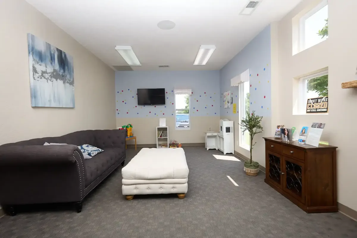 A wide view of the comfortable family lounge with a large sofa and ottoman