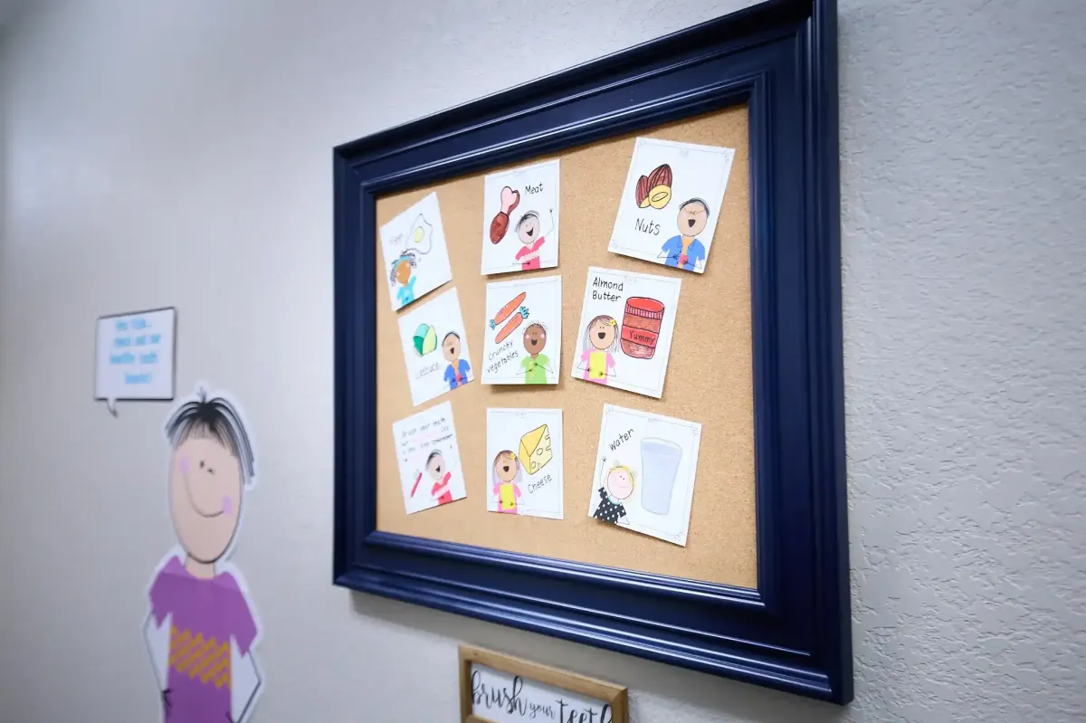 A display board featuring colorful drawings for young patients at Cardinal Dental