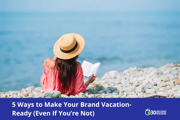 Woman in a straw hat and coral top sits on a rocky beach reading a book, facing a calm blue sea. Text overlay reads “5 Ways to Make Your Brand Vacation-Ready (Even If You’re Not)” with the 30 Second Success logo.