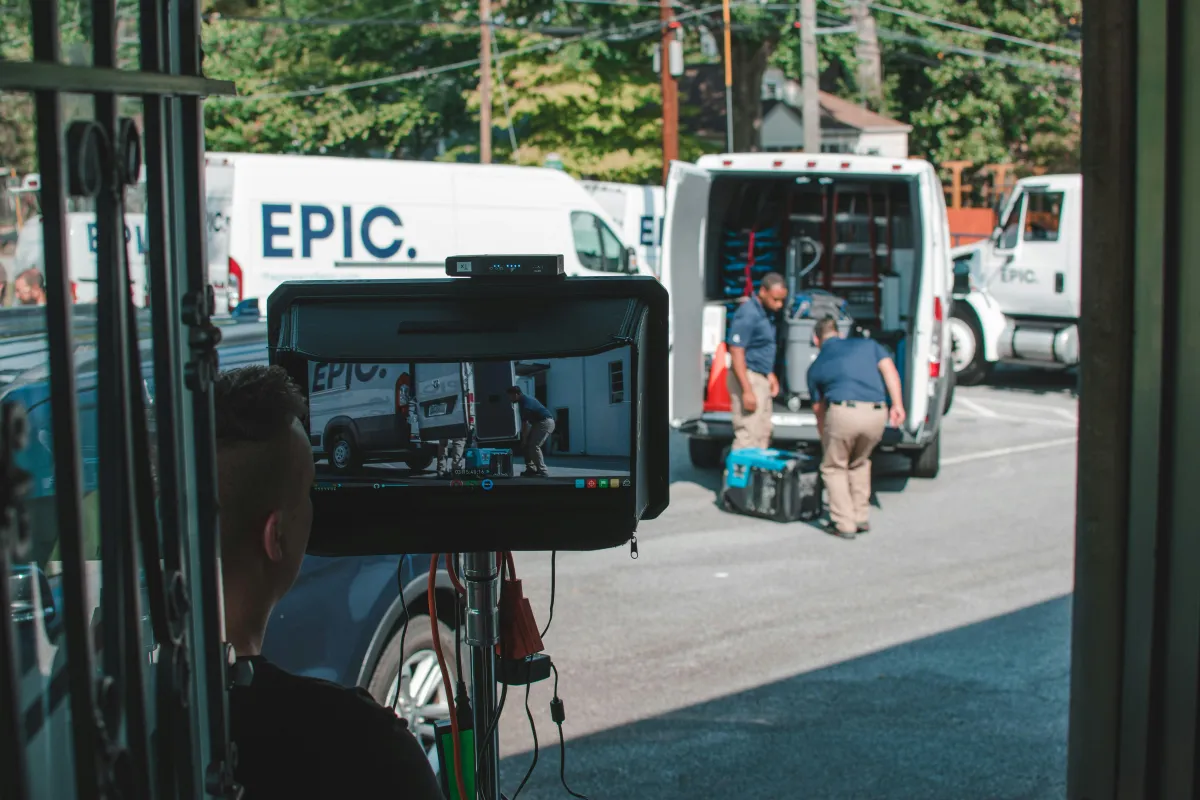 Cover image for a blog post on managing the slow season in video production, depicting a calendar with marked slow months, a video camera, and a laptop with editing software. Additionally, it includes educational materials like books or online courses. The background features an optimistic sunrise and budding plants, symbolizing new opportunities and growth potential during quieter business periods