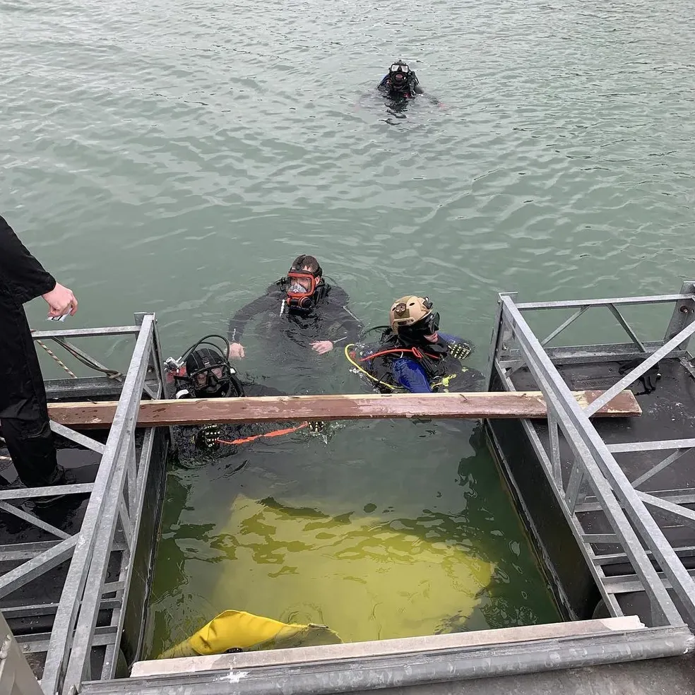 Underwater shot of a volunteer retrieving essential rescue equipment