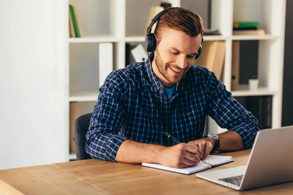 A man listening to a podcast about how learning writing skills can help his speaking