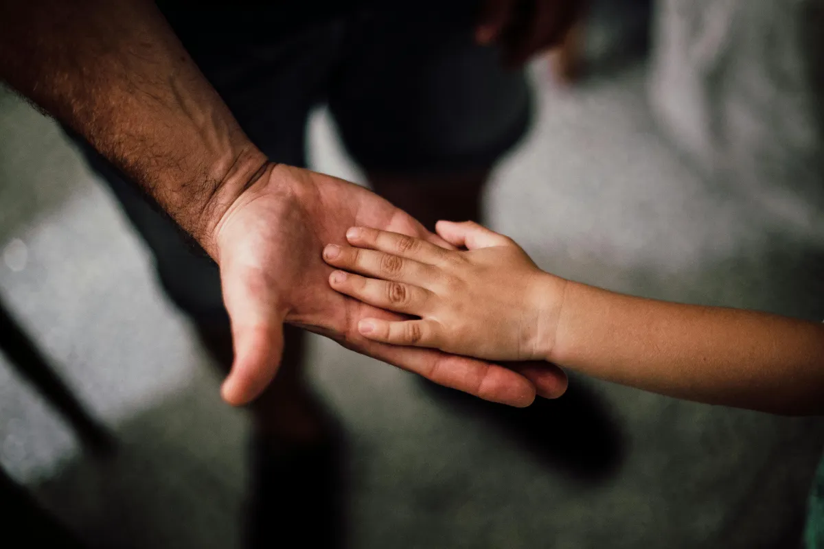 A parent holding a childs hand