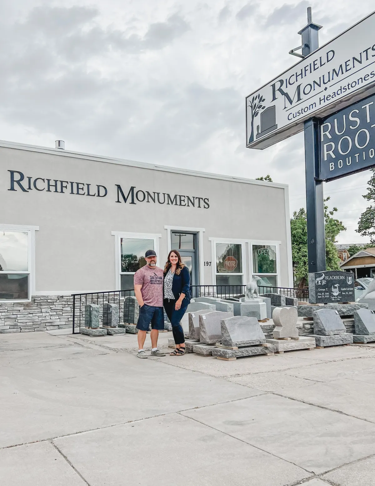 Owners of Richfield Monuments standing beside custom headstones, showcasing their craftsmanship in Richfield, Utah.