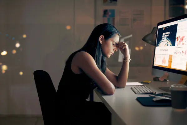 woman sitting in front of computer and feeling burned out