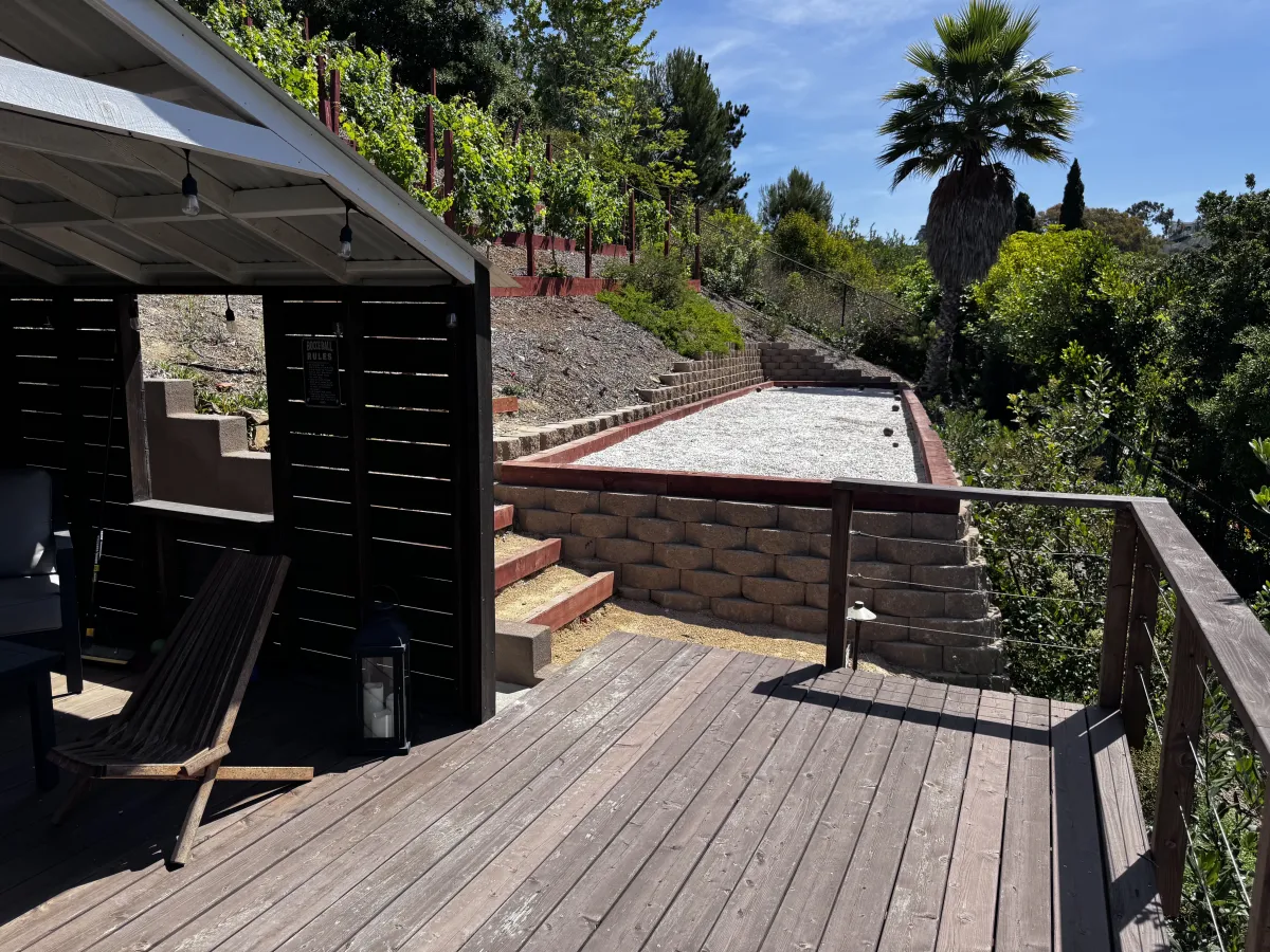 Custom bocce ball court integrated into a terraced hillside with stone retaining walls.
