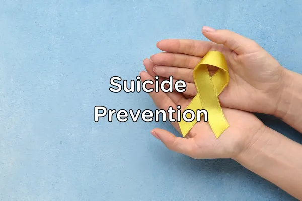 A pair of hands cradled the yellow suicide awarenss ribbon over a light blue background