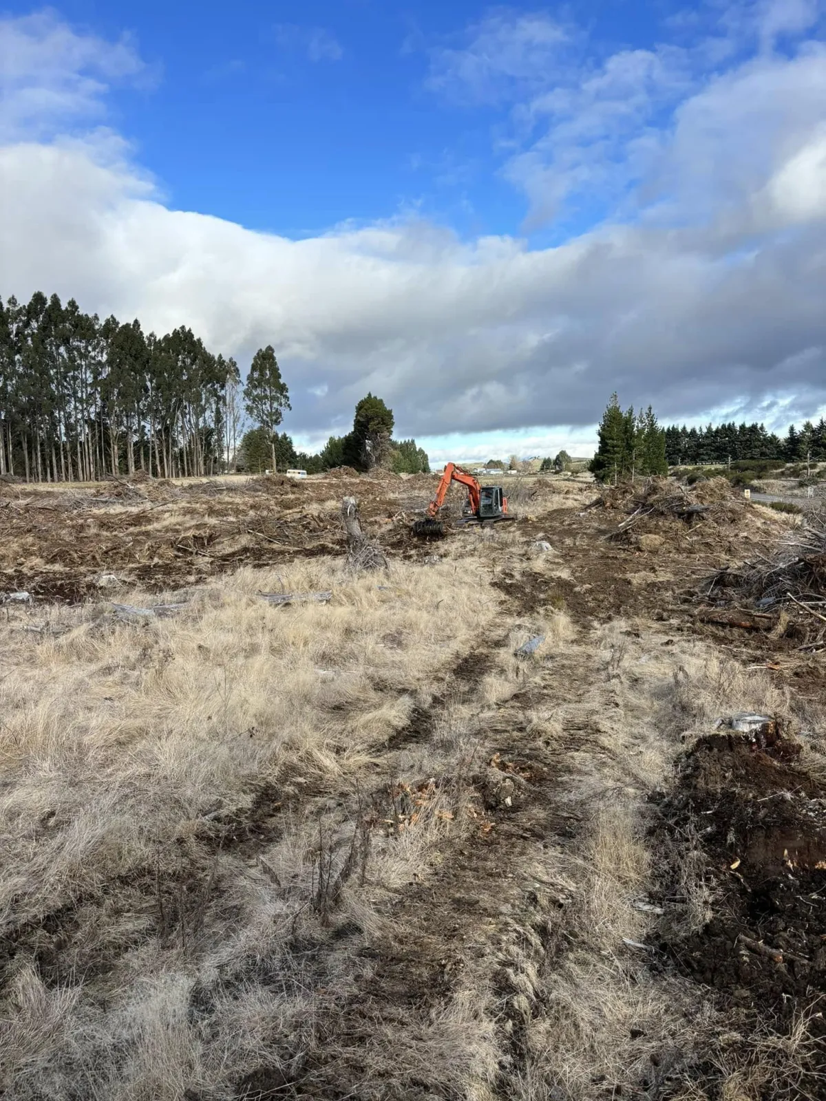 Excavator digging into the earth at a site near Ohakune for a construction project.